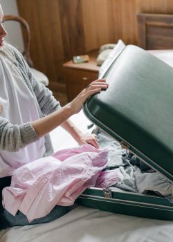 focus woman packing suitcase on bed